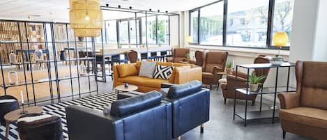A modern lounge area with leather sofas, a coffee table, and a patterned rug.
