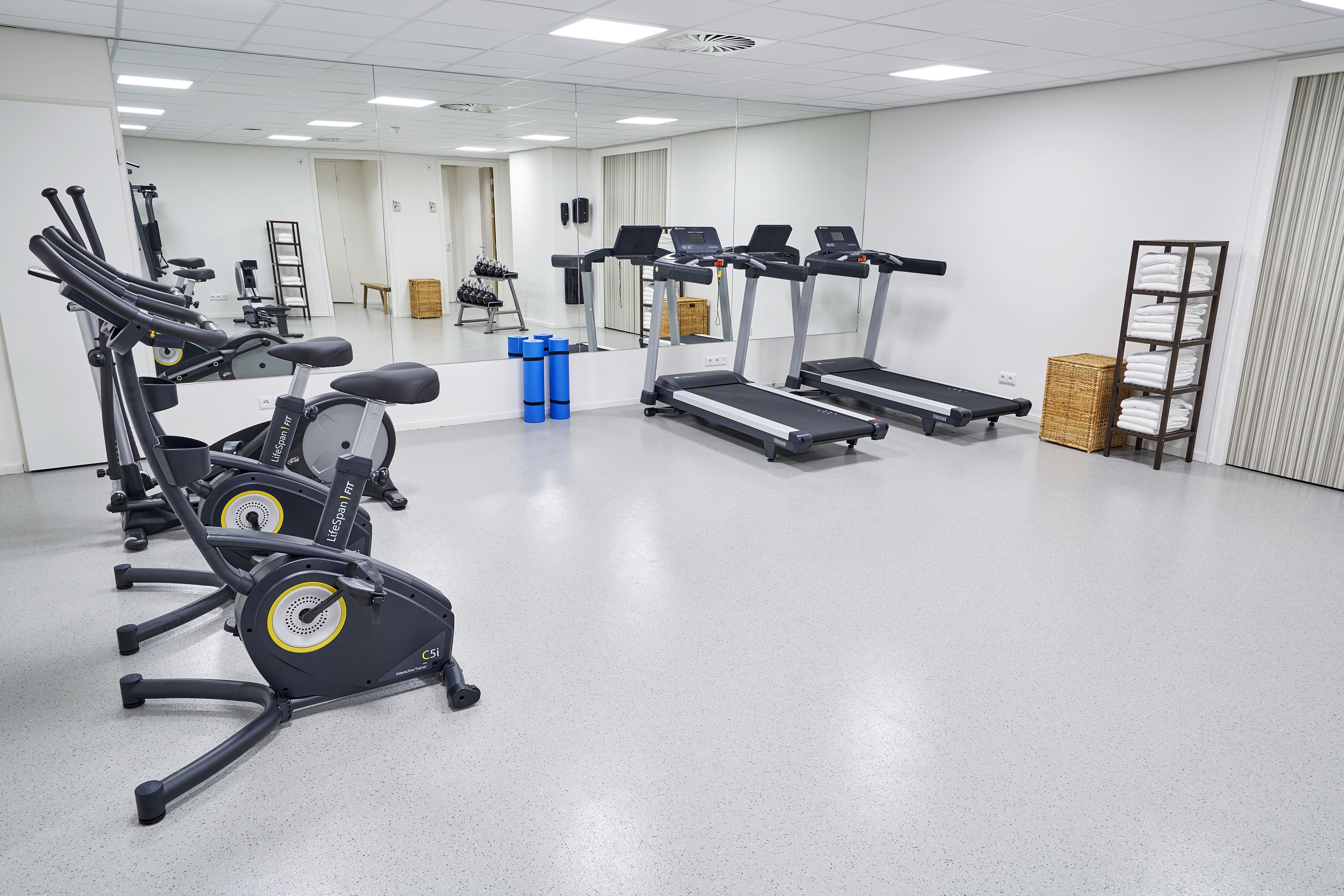Ein Fitnessstudio mit Ergometer, Laufbändern und Trainingsgeräten.
