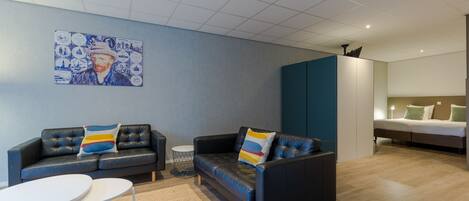 A modern living room with a sofa, a coffee table, and a painting on the wall.