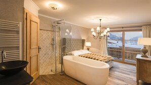 Een moderne badkamer met een bad, douche en wastafel.