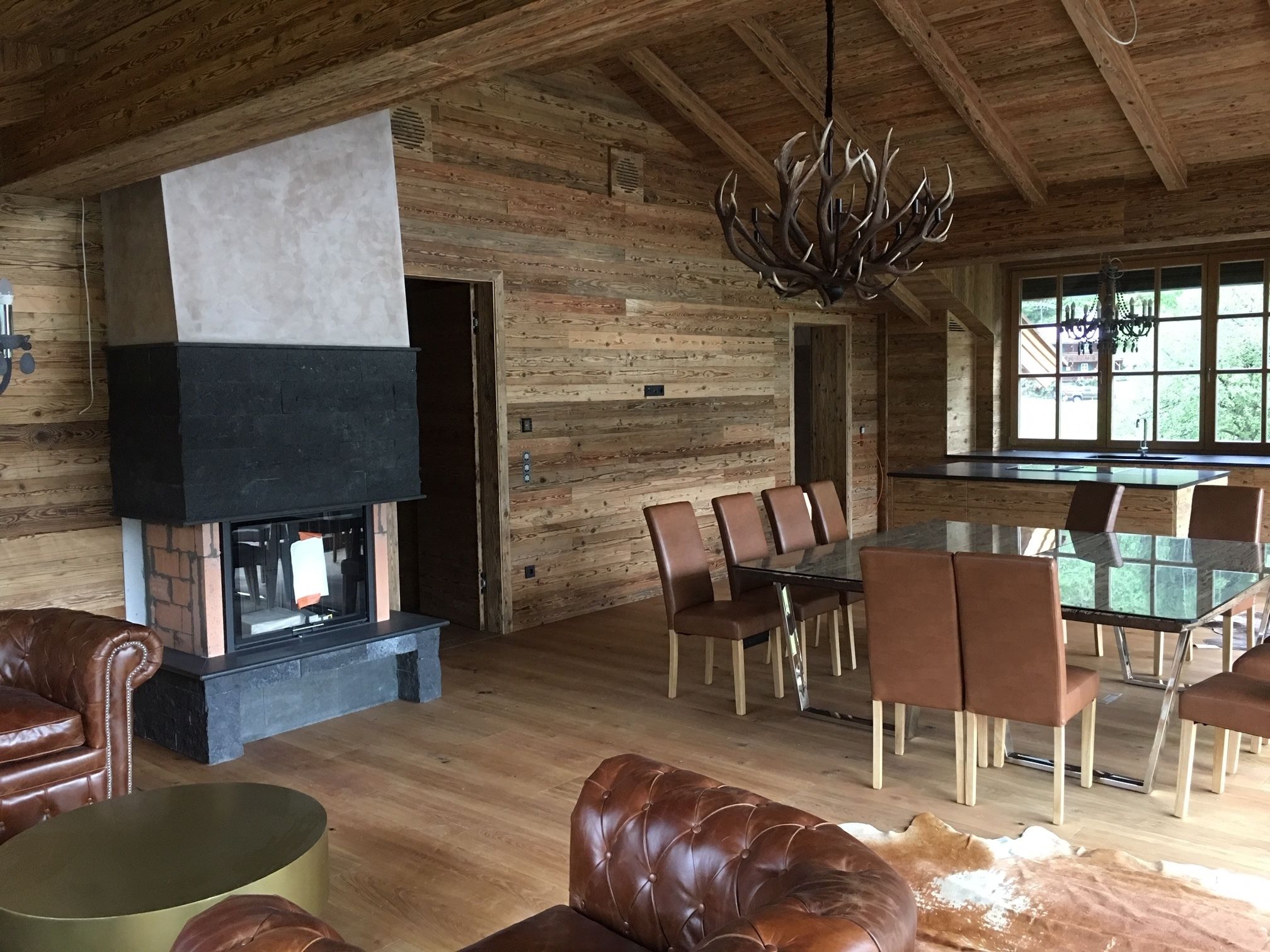 Un intérieur rustique avec une cheminée, des meubles en cuir et un coin repas.