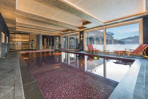 Una piscina techada, sillones reclinables de piscina