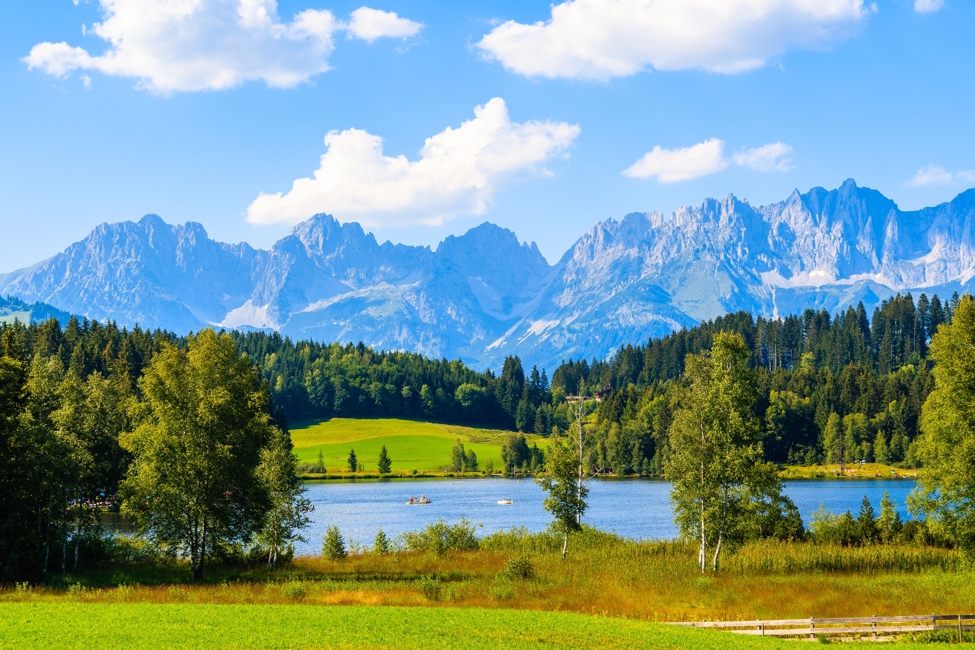 A mountainous landscape with a lake and forested area.