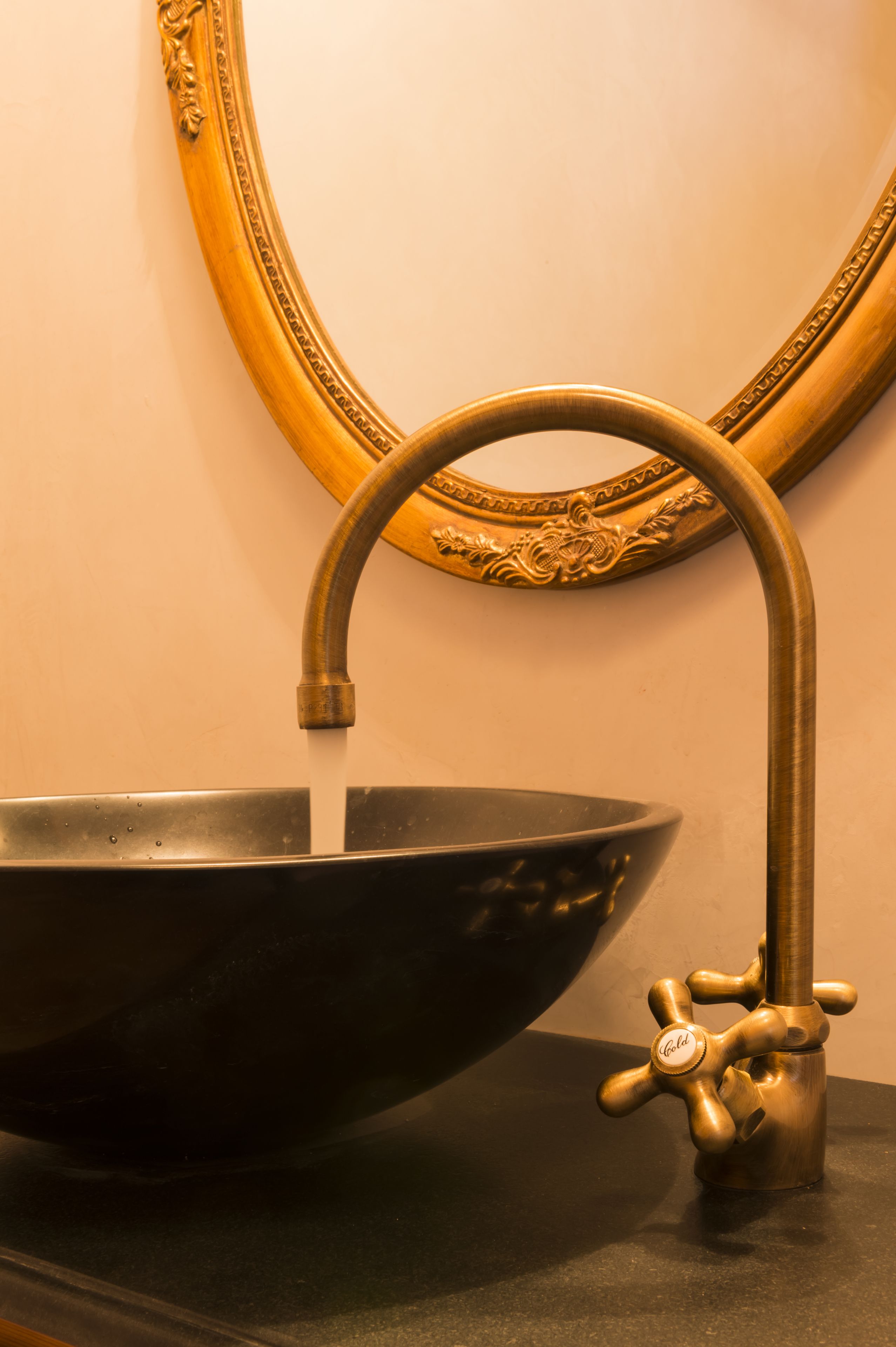 Un grifo de bronce con un lavabo.