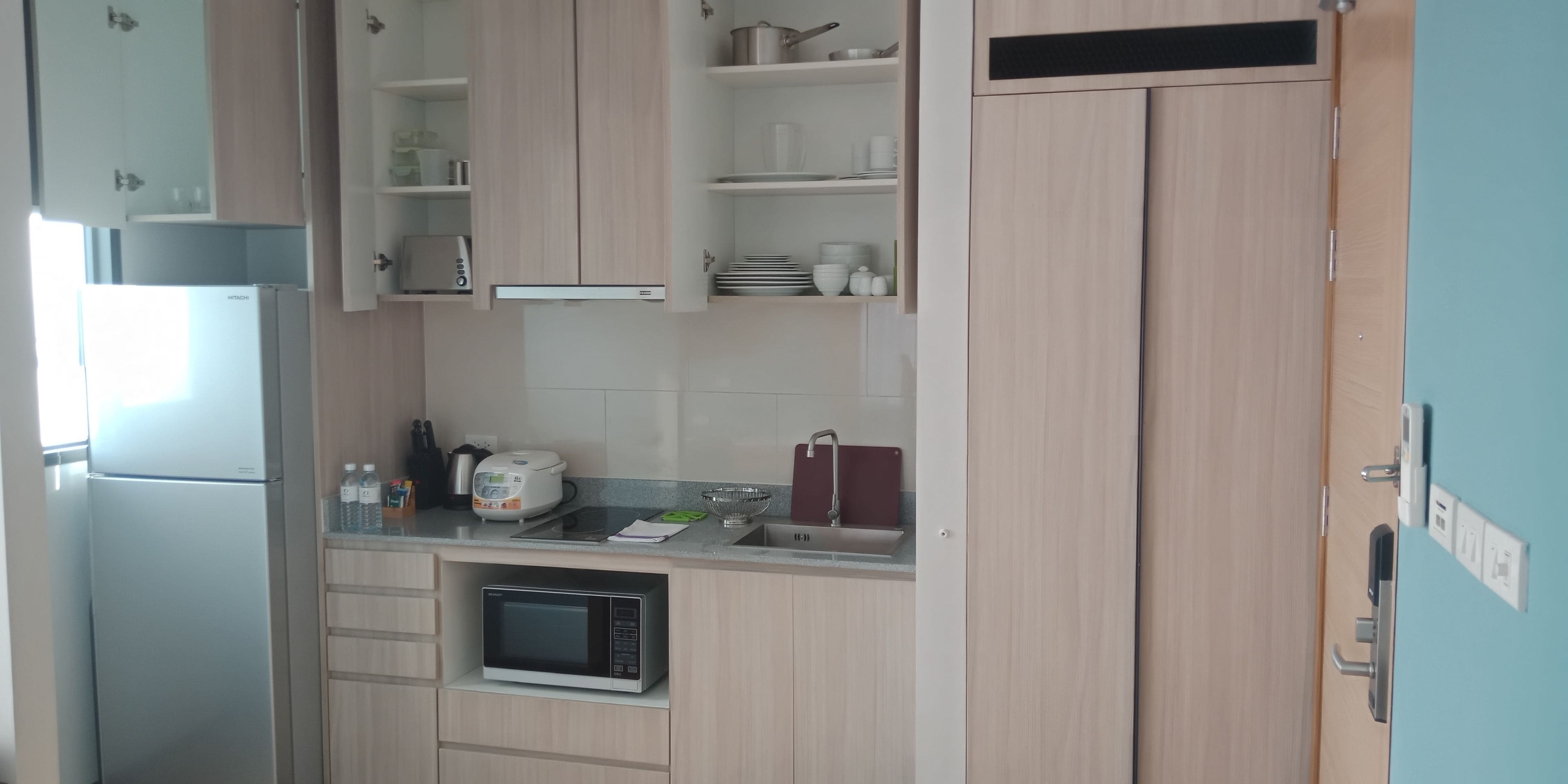 A compact kitchen with a built-in microwave, a toaster, and a sink.