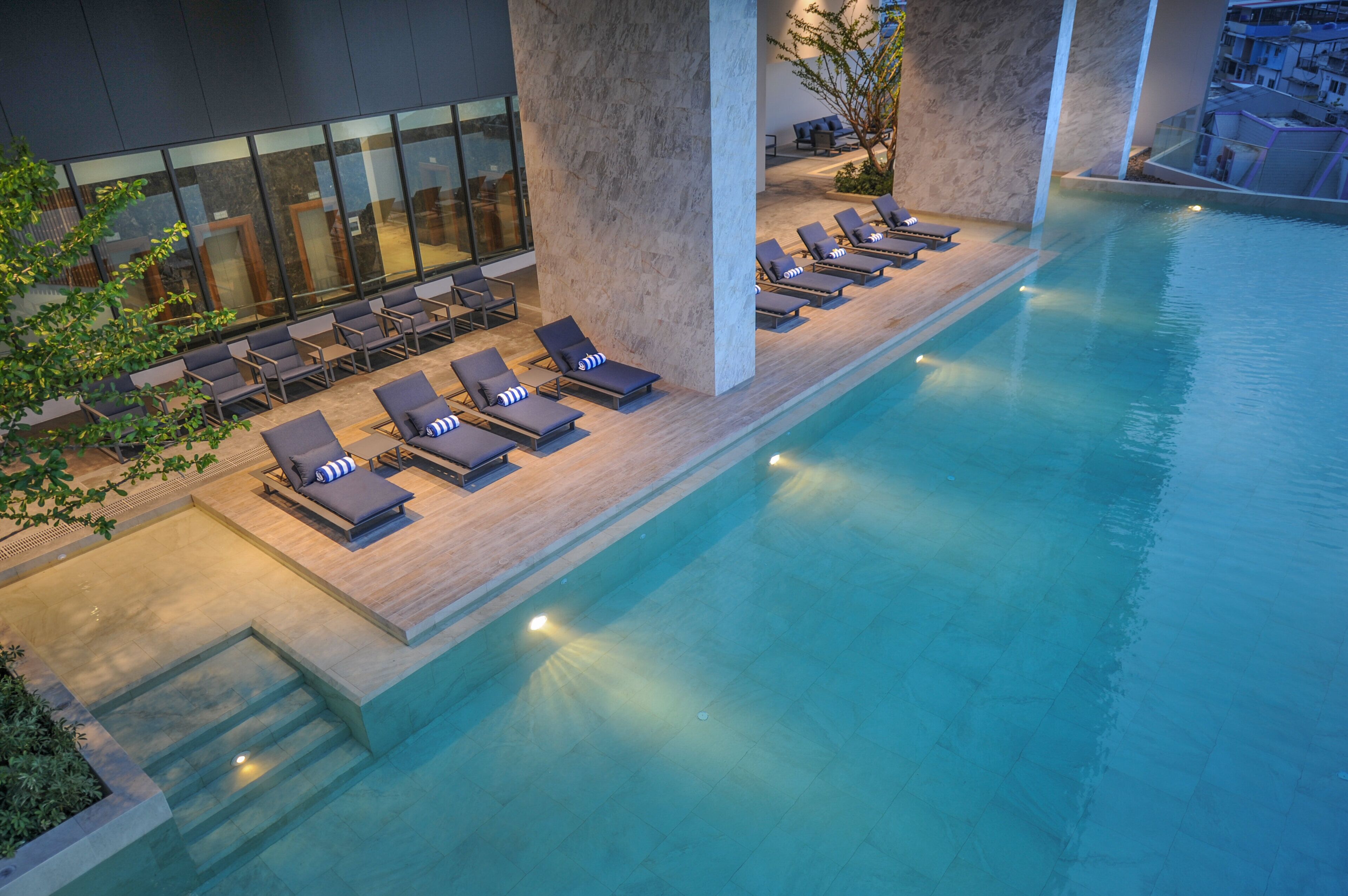 A rooftop infinity pool with lounge chairs and a modern architectural design.