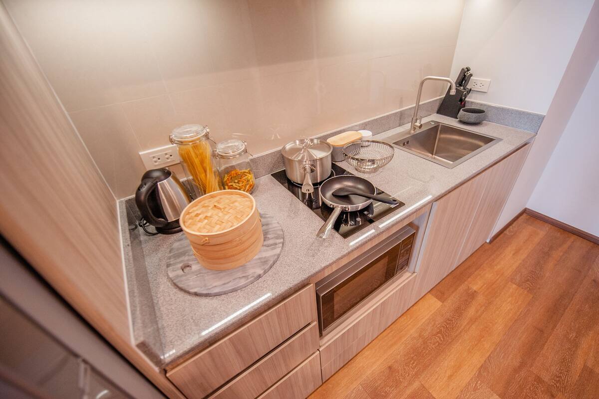 Eine moderne Küche mit Granit Arbeitsplatte, Edelstahlgeräten und Holzschränken.