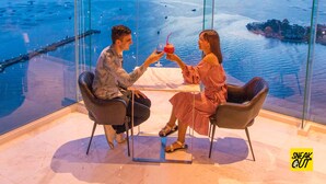 A high-rise hotel room with a panoramic sea view, a dining table, and a hanging light fixture. - Oakwood hotel & Residence Sri Racha (Si Racha)
