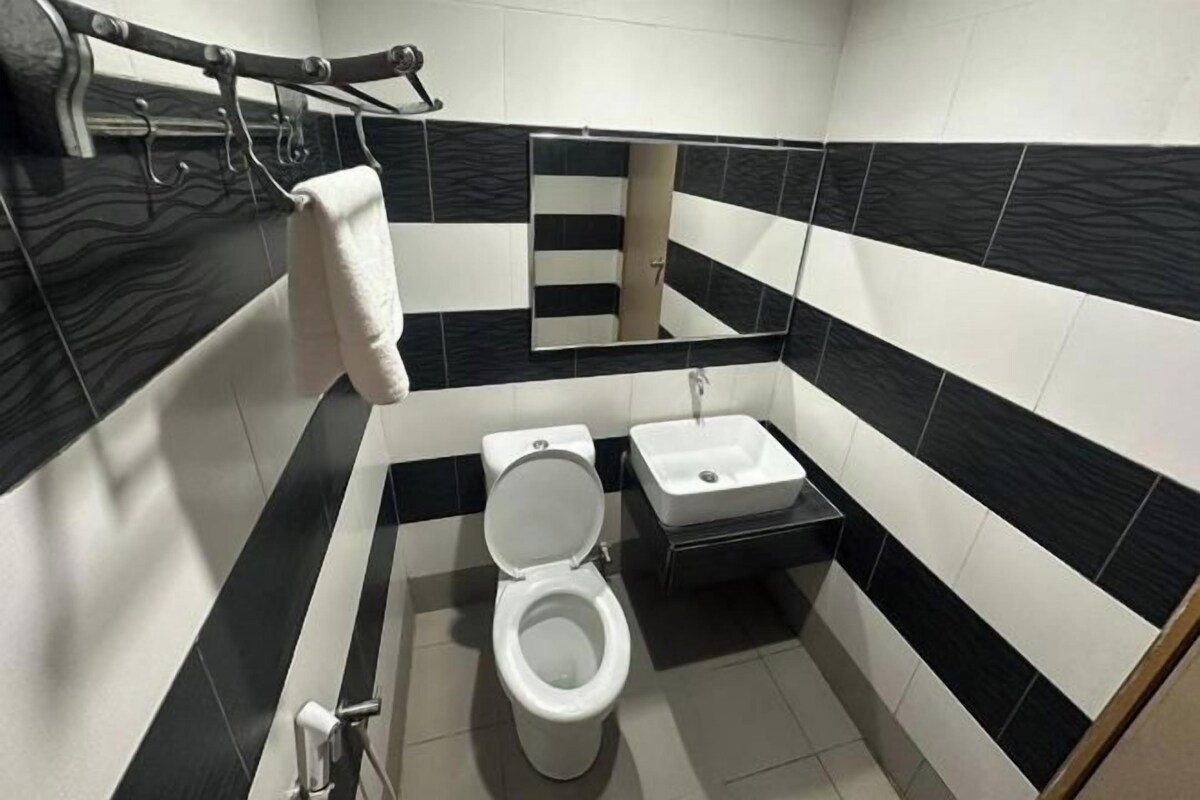 A bathroom with a toilet, sink, and towel rack.