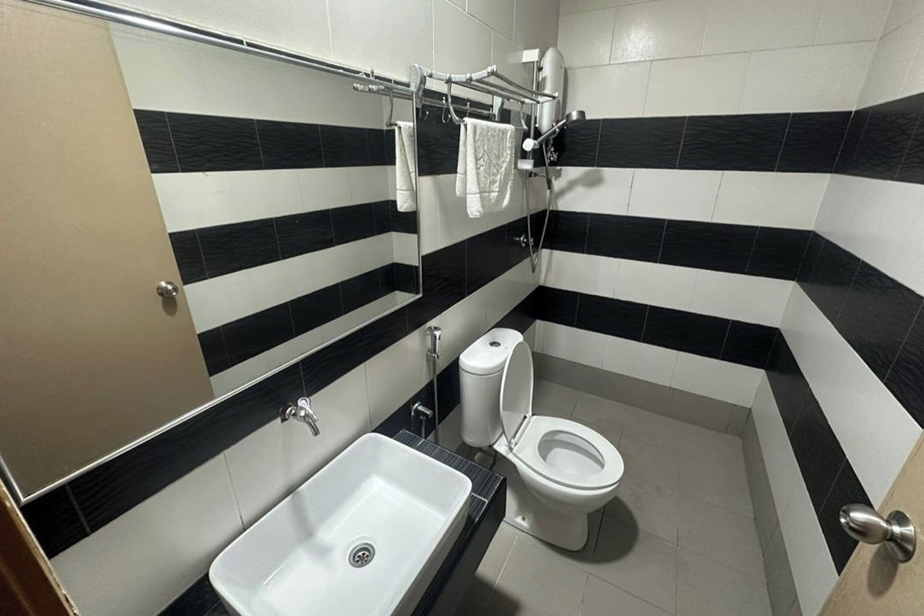 A modern bathroom with a white sink, a toilet, and a mirror.