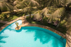 A swimming pool surrounded by palm trees and lounge chairs. - La Résidence Dakar (Dakar)