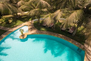 Una piscina al aire libre, tumbonas
