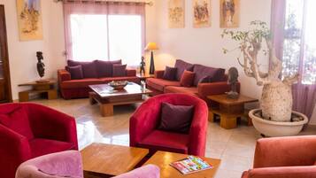Una sala de estar con sofás rojos, una mesa de centro y una planta en maceta.