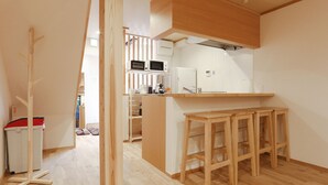Een moderne keuken met houten krukken, een magnetron en een koelkast.