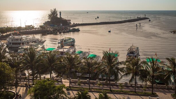 A coastal area with a pier, boats, and a lighthouse. - Phu Hong Hotel (Phu Quoc)