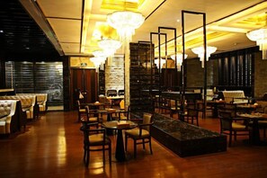 A hotel lobby with a bar area, seating arrangements, and a large chandelier. - Donghui Hotel (Dongguan)