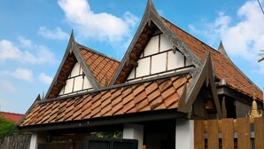 A traditional building with a steeply pitched roof, wooden beams, and a tiled roof. - Hua Hin Home (Hua Hin)