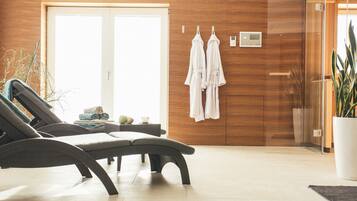 Relax in a serene spa room with a lounge area, changing station, and amenities at your fingertips.