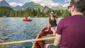 A wooden boat on a lake with mountains in the background.