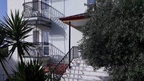 A white building with a spiral staircase leading to a balcony. - Hotel Babadag (Fethiye)
