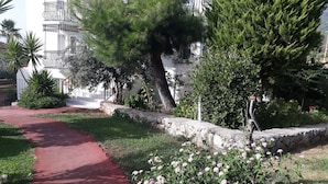 A pathway leading to a building with balconies, surrounded by greenery and flowering plants. - Hotel Babadag (Fethiye)