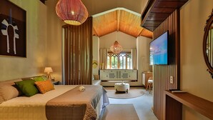 A spacious bedroom with a large bed, a television, and a view of the outdoors through a window with a decorative grille. - Recanto do Arraial - Pousada (Porto Seguro)