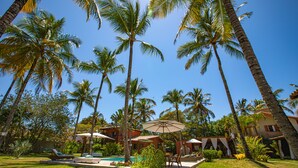 A tropical resort with a swimming pool, palm trees, and outdoor seating areas. - Recanto do Arraial - Pousada (Porto Seguro)
