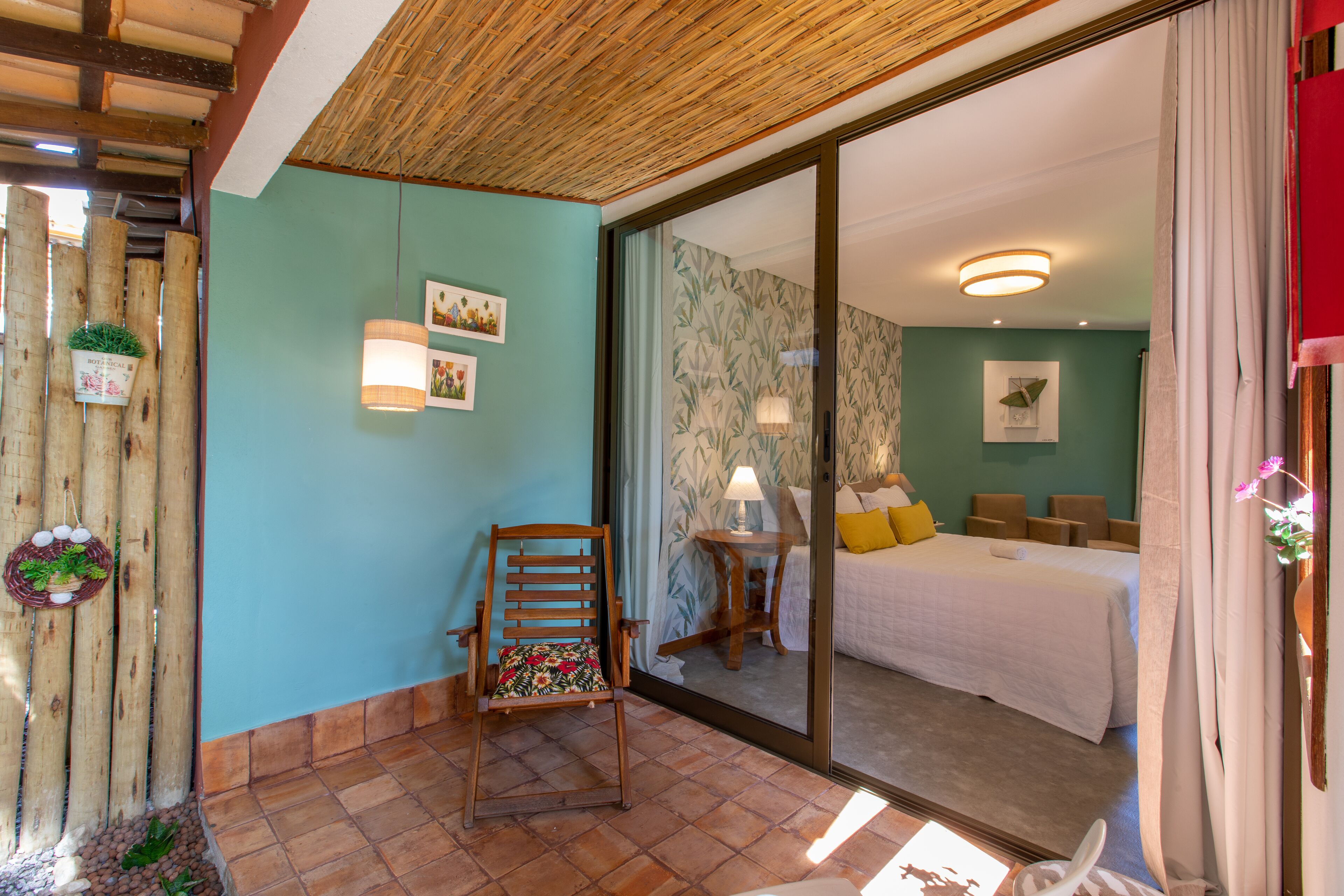 Une pièce comprenant un lit, une chaise, une petite table et un miroir.
