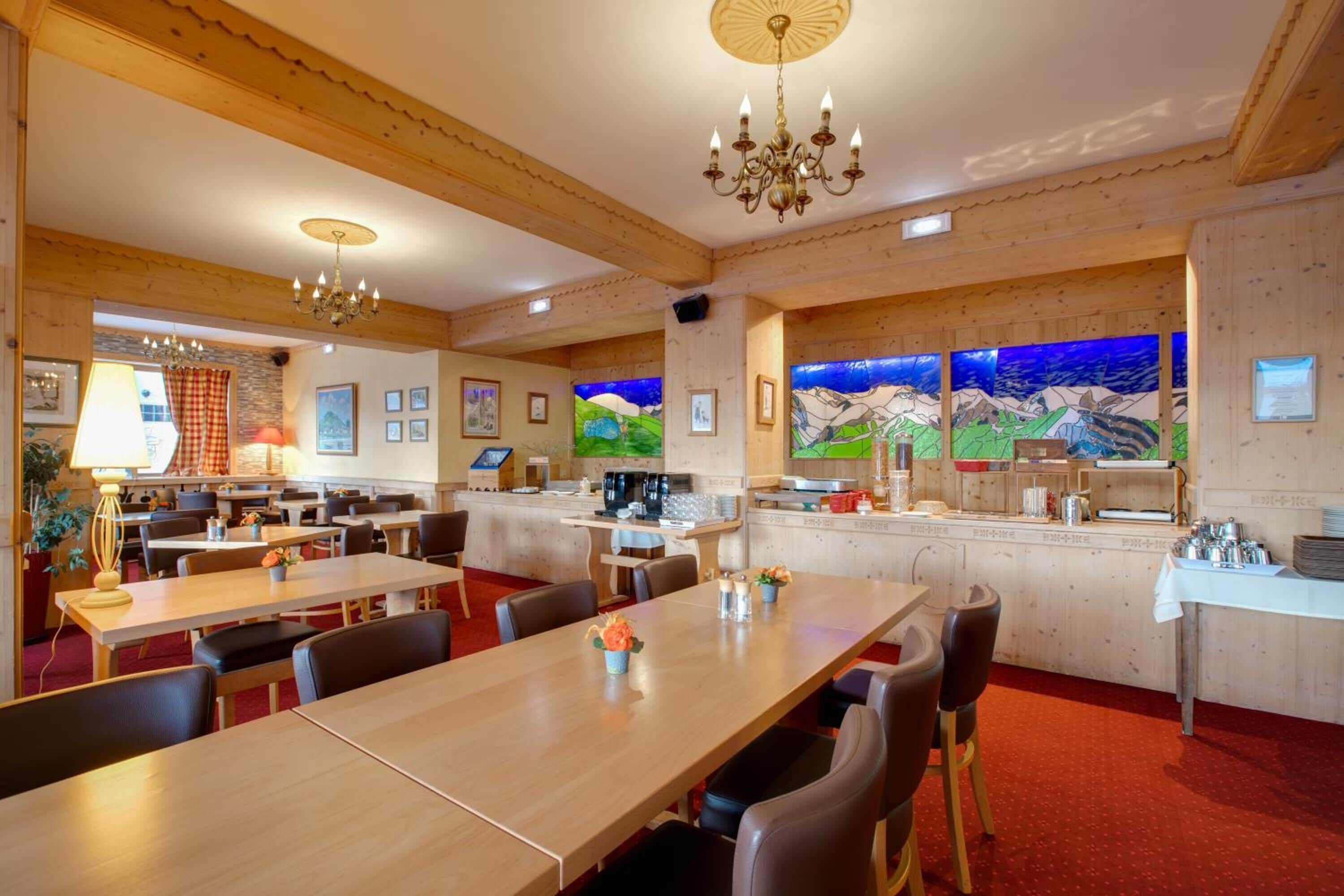 A restaurant with wooden walls and ceiling, multiple dining tables, and a bar area.