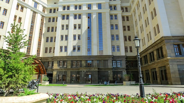 A multi-story building with a central entrance, large windows, and a symmetrical facade.