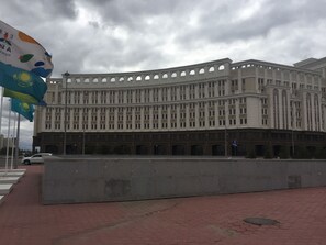 Un grand immeuble à étages, doté d’une façade symétrique, de nombreuses fenêtres et d’ouvertures en arc de cercle.