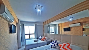 A hotel room with two beds, a large mirror, and an air conditioning unit on the wall. - Atlântico Tambaú Home Service (João Pessoa)