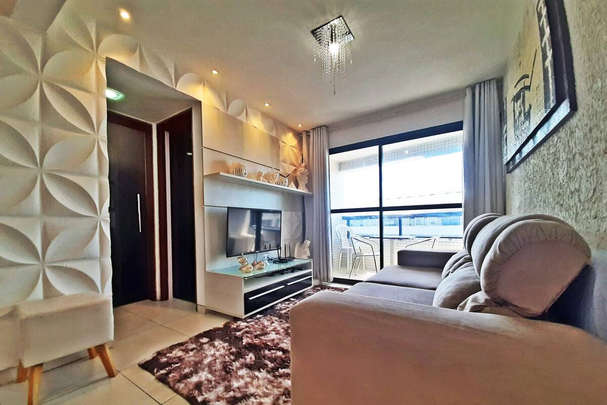 Ein modernes Wohnzimmer mit einer Couch, Fernseher und Dekorationselementen.