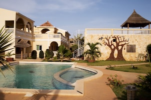 Una piscina al aire libre, sombrillas, tumbonas