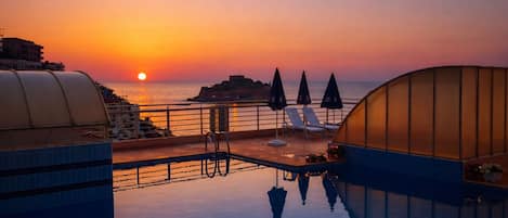 Een buitenzwembad en ligstoelen