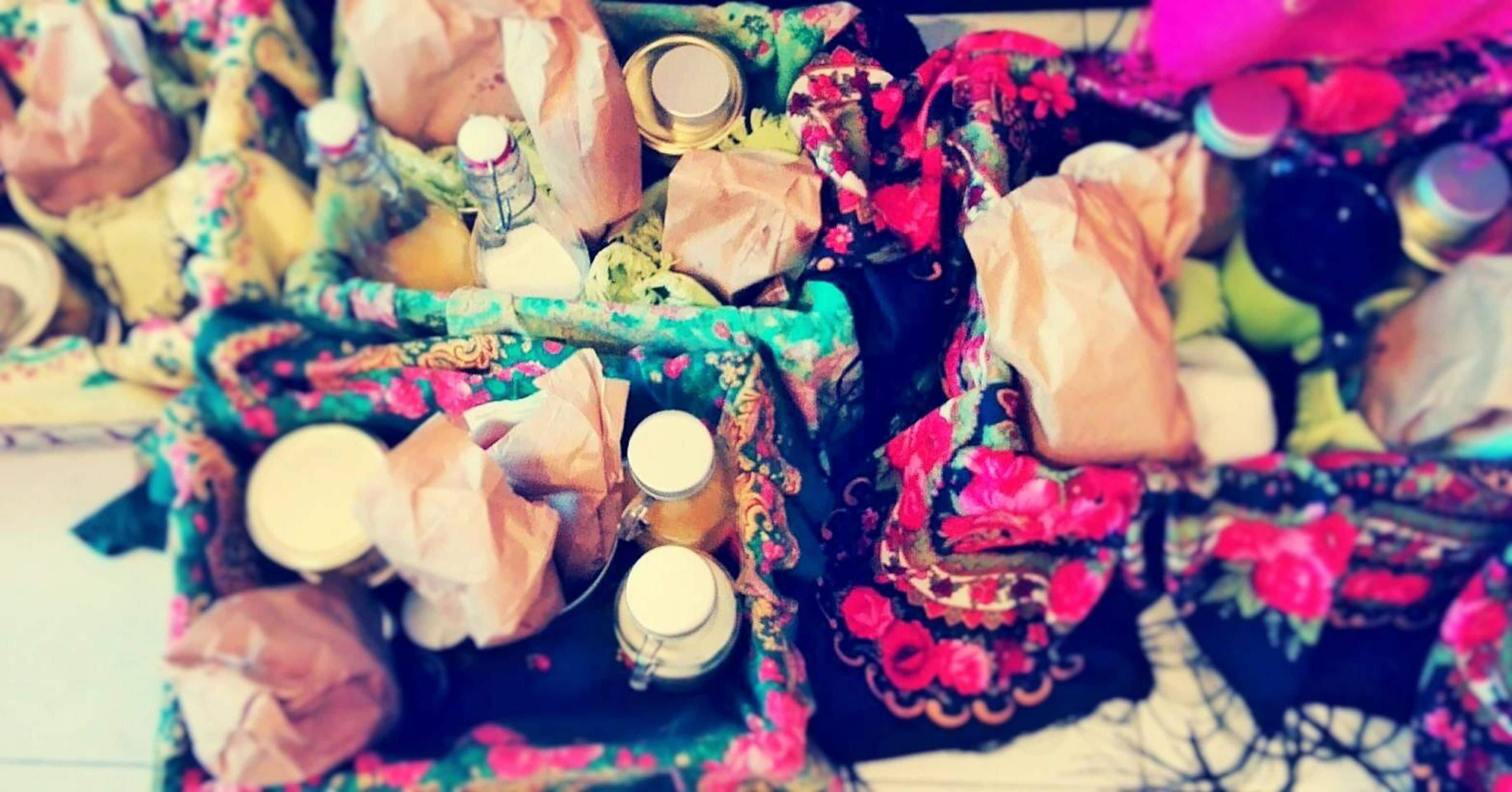 A cluttered space with various items including bottles, papers, and a patterned fabric.