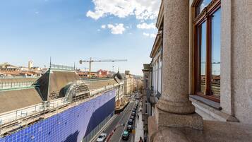 A view of a city street with a construction site, a bridge, and buildings.