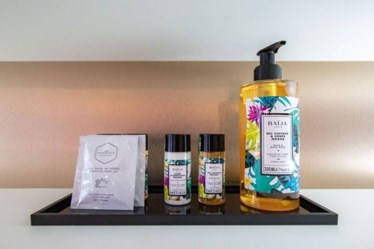 A tray with a bottle of Baija gel, two smaller bottles, and a white paper bag.