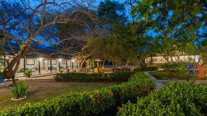 A courtyard with a building, trees, and a pathway. - Pousada Rio Claro (Pocone)