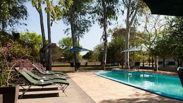 Alberca al aire libre y camastros