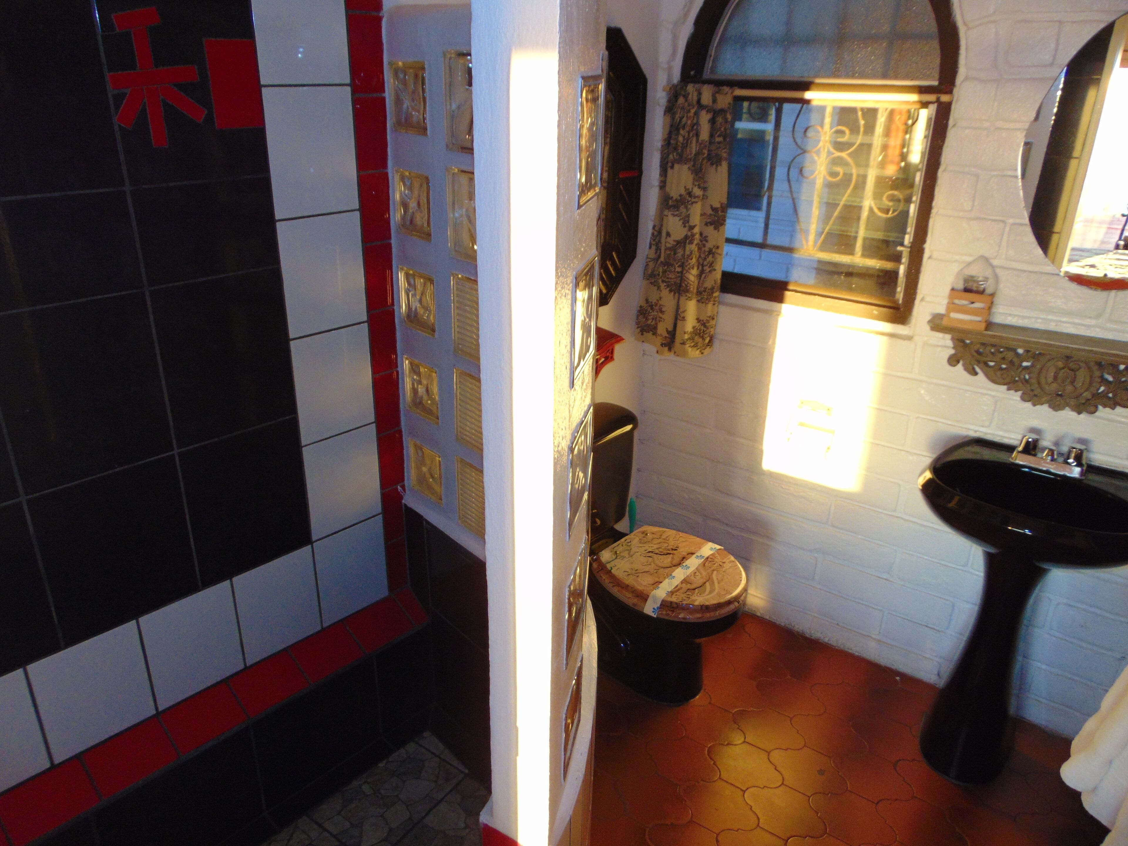 Un baño con inodoro, lavamanos y paredes de azulejos.