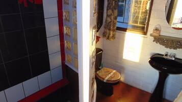 Un baño con inodoro, lavamanos y paredes de azulejos.