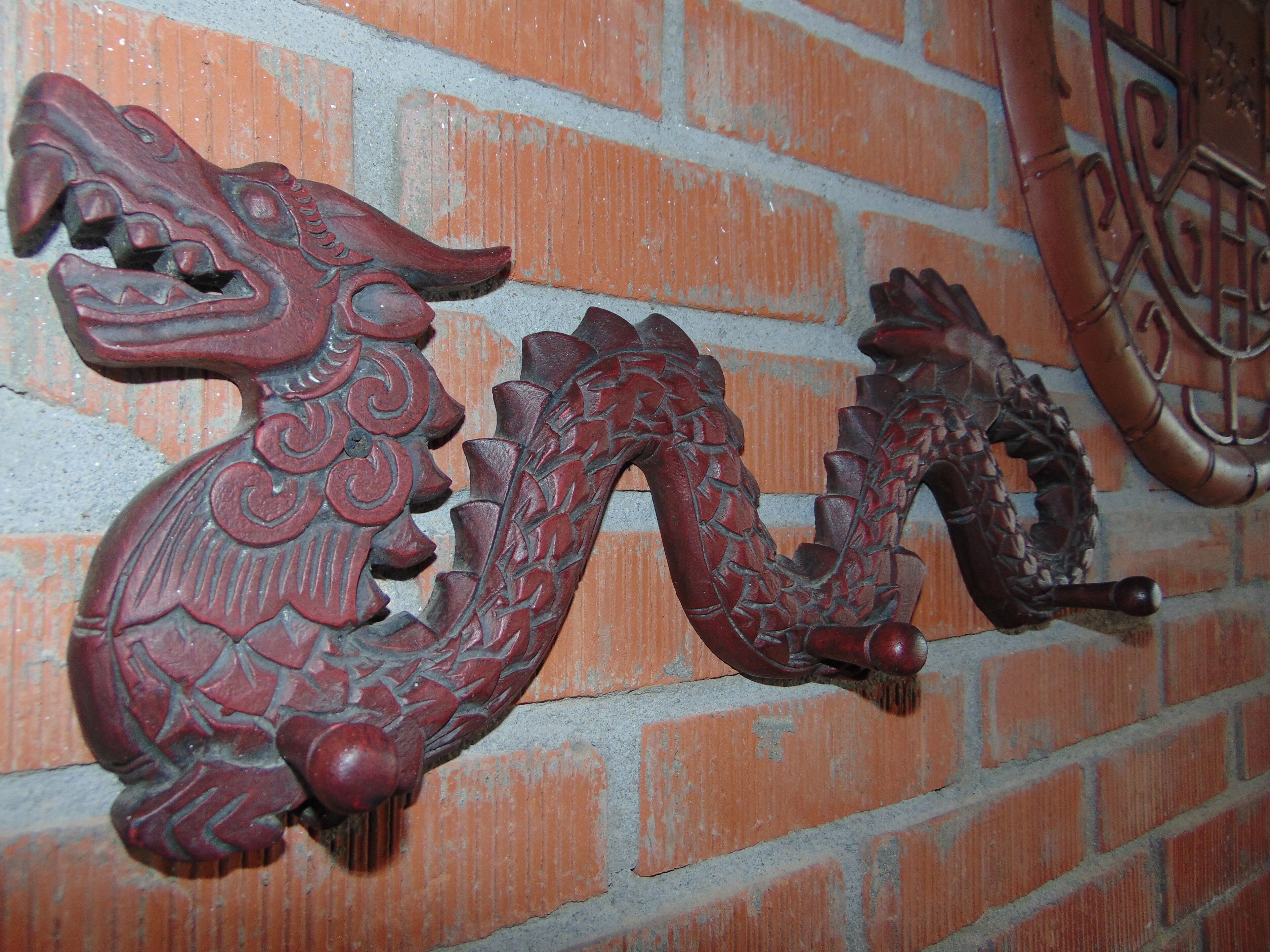 A wall with a decorative dragon sculpture.