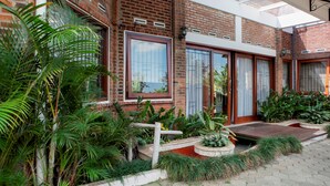 A brick building with large windows and a covered patio area. - RedDoorz Plus near Dago Pakar (Bandung)