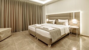 A modern hotel room with a large bed, a bedside table, and a chair. - Remezzo Apartments & Studios (Zakynthos)
