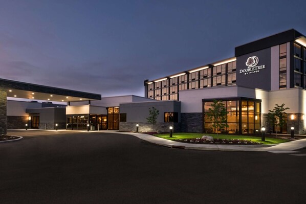 A modern hotel with a prominent DoubleTree logo, featuring a well-lit entrance and a landscaped garden area. - Doubletree by Hilton Lafayette East, IN (Lafayette)