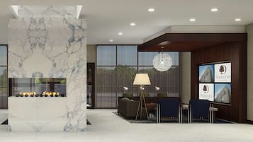 A modern lobby with a marble fireplace, seating area, and large windows.