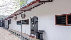 A building with a white exterior, a metal awning, and a sign indicating a cafe.
