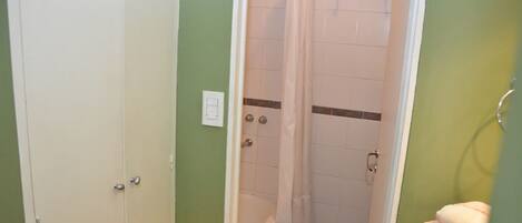 Een badkamer met een douche, toilet en wastafel.