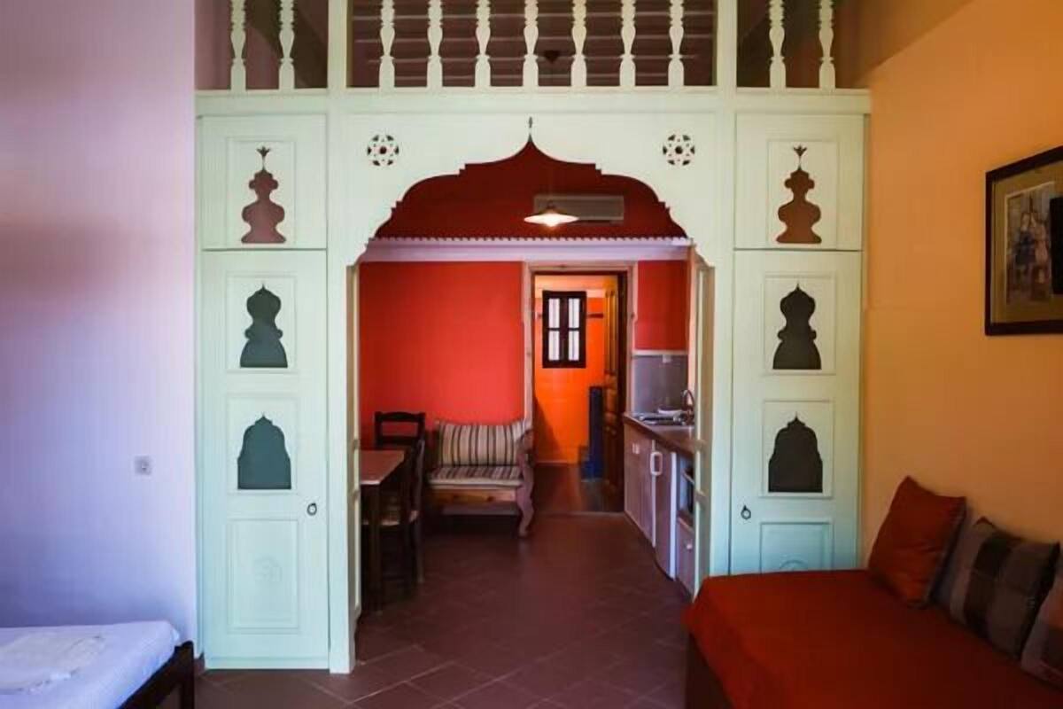 Una habitació amb un llit, taula de menjador i zona de cuina.